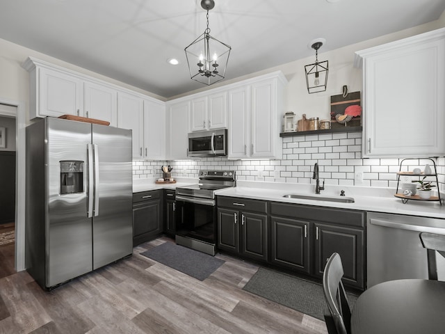 41698 Brownstone Dr, Novi, MI 48377 - kitchen with appliances with stainless steel finishes, a sink, white cabinetry, and light countertops