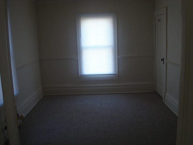 carpeted empty room with baseboards