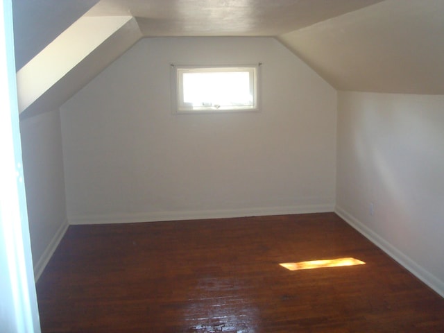 additional living space featuring lofted ceiling, baseboards, and wood finished floors