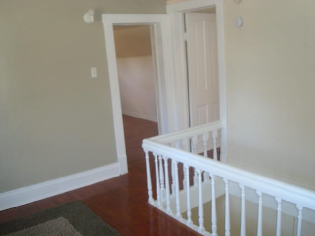 hall featuring wood finished floors and baseboards