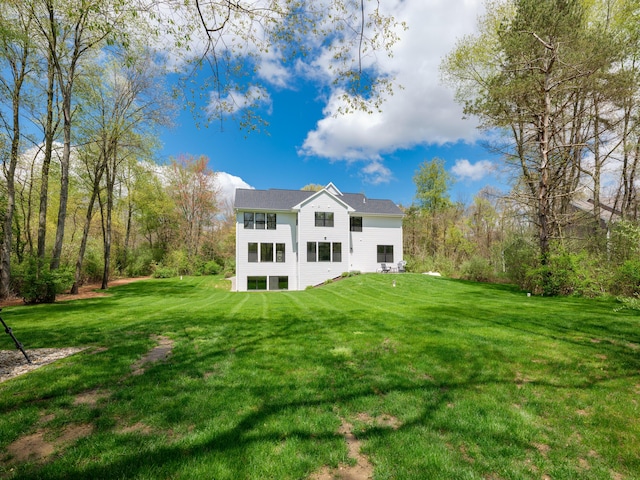 rear view of property featuring a lawn