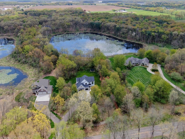 drone / aerial view featuring a water view and a wooded view