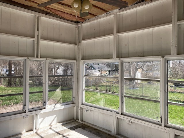 unfurnished sunroom featuring a ceiling fan