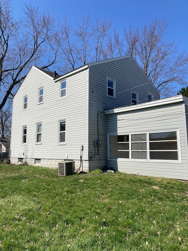 back of property featuring a yard and central AC