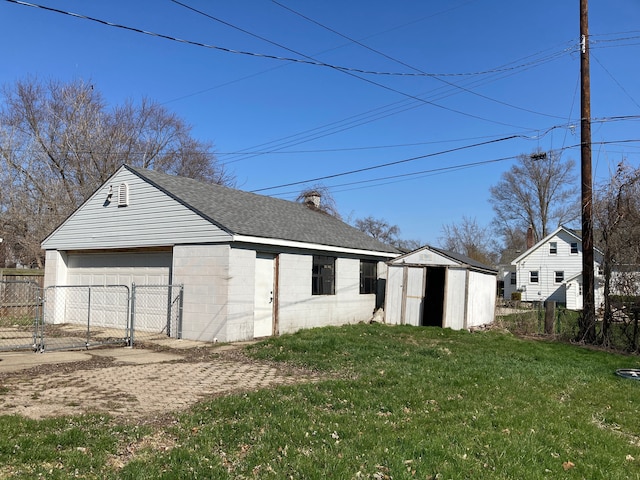 detached garage featuring fence, a storage unit, and a gate