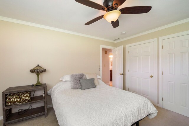 carpeted bedroom with visible vents, ornamental molding, and a ceiling fan