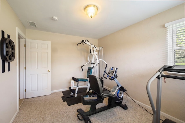 exercise room with visible vents and baseboards