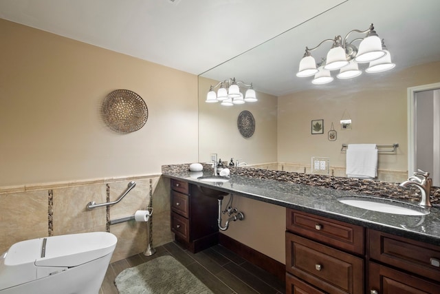 full bath with wainscoting, toilet, double vanity, and a sink