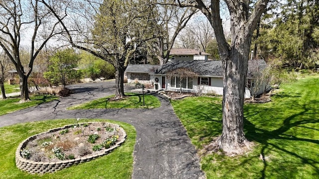 view of front of house featuring a garage, aphalt driveway, and a front yard