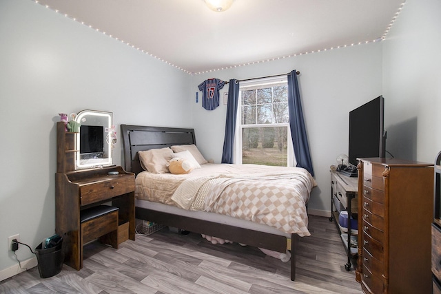 bedroom featuring baseboards and wood finished floors