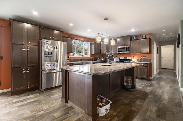 kitchen with recessed lighting, stainless steel appliances, dark brown cabinets, stone counters, and pendant lighting