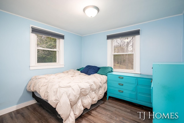 bedroom with multiple windows, baseboards, ornamental molding, and dark wood-type flooring