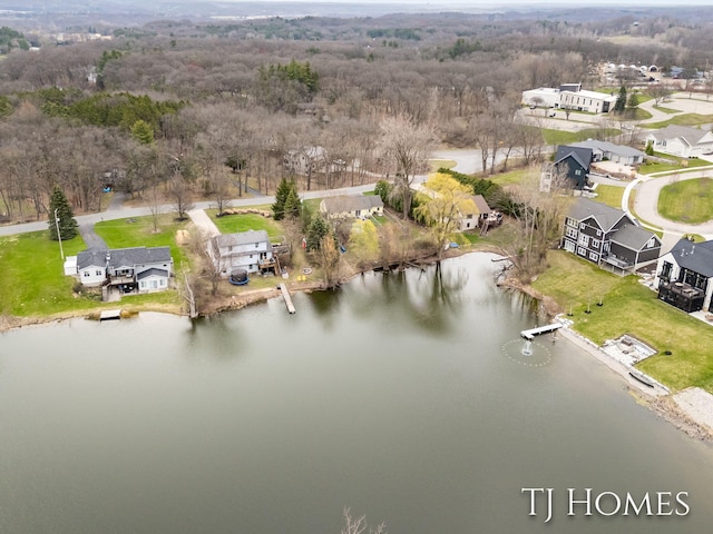 birds eye view of property featuring a forest view, a water view, and a residential view