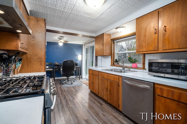 kitchen with dark wood-style floors, an ornate ceiling, light countertops, under cabinet range hood, and appliances with stainless steel finishes