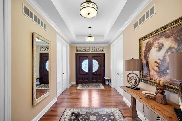 70799 Fisher Rd, Bruce, MI 48065 - foyer entrance featuring wood finished floors, visible vents, a tray ceiling, and baseboards
