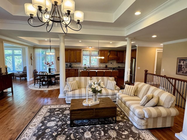 70799 Fisher Rd, Bruce, MI 48065 - living area with a chandelier, ornate columns, a healthy amount of sunlight, and a tray ceiling