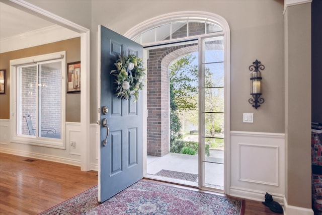 8504 Riverwalk Dr, Fenton, MI 48430 - entrance foyer with a wainscoted wall, wood finished floors, a decorative wall, and ornamental molding