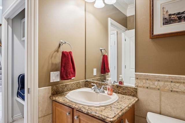 8504 Riverwalk Dr, Fenton, MI 48430 - half bathroom featuring tile walls, toilet, vanity, wainscoting, and ornamental molding