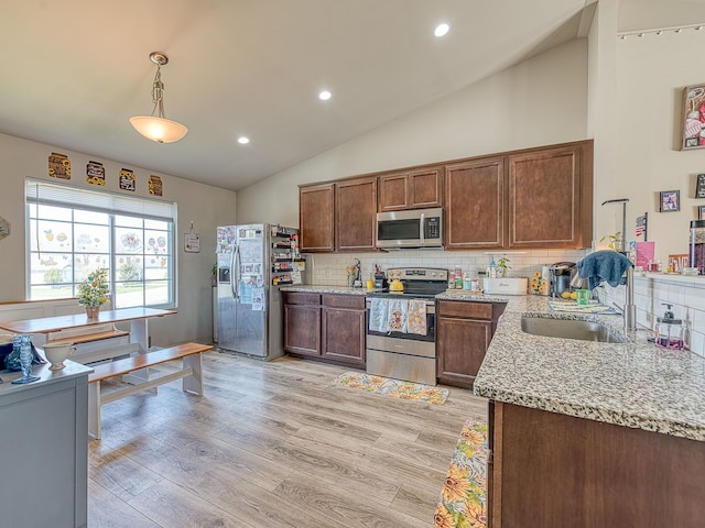 159 St Clair Cir, Brooklyn, MI 49230 - kitchen featuring light stone counters, stainless steel appliances, backsplash, vaulted ceiling, and light wood-style flooring