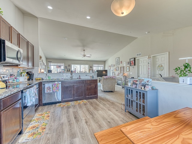 159 St Clair Cir, Brooklyn, MI 49230 - kitchen with a peninsula, light wood-type flooring, open floor plan, lofted ceiling, and appliances with stainless steel finishes