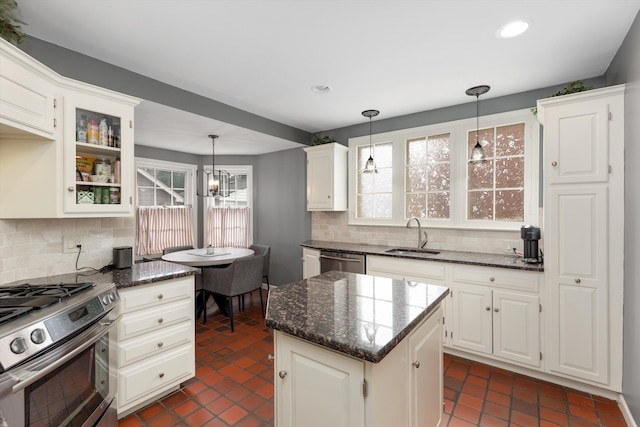 kitchen featuring appliances with stainless steel finishes, a sink, healthy amount of natural light, backsplash, and recessed lighting