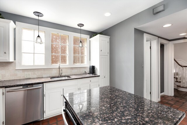 kitchen with stainless steel dishwasher, a sink, white cabinetry, decorative backsplash, and recessed lighting