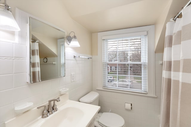 bathroom featuring tile walls, a sink, toilet, and a shower with shower curtain