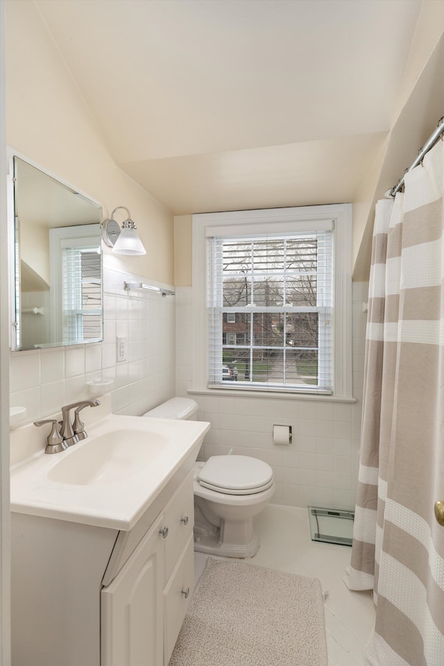 full bathroom with tile walls, baseboard heating, vanity, toilet, and tile patterned floors