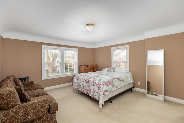 bedroom with light colored carpet and baseboards
