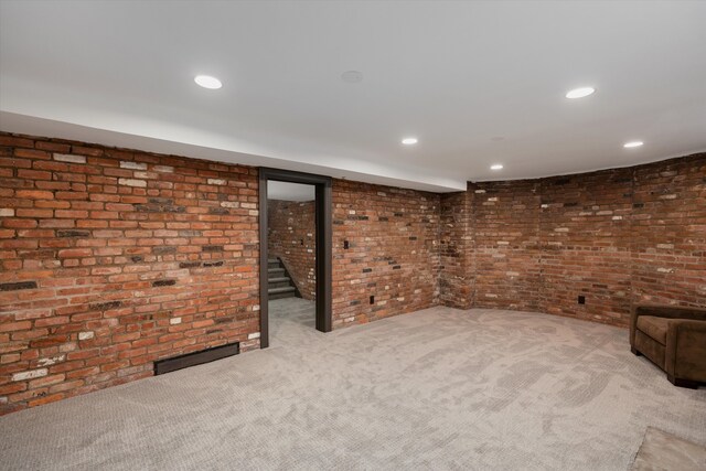 finished below grade area with brick wall, carpet, and recessed lighting