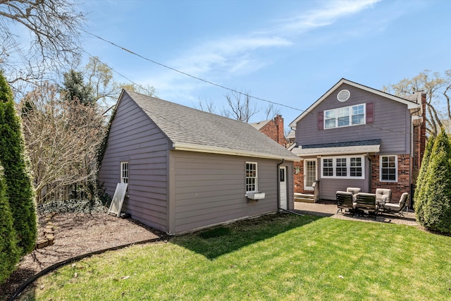 rear view of house featuring an outdoor structure, a lawn, a patio, brick siding, and outdoor lounge area