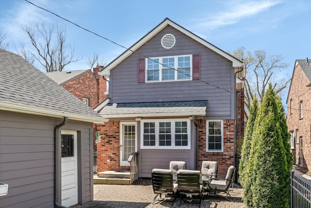 back of house featuring brick siding, outdoor lounge area, a patio, and fence