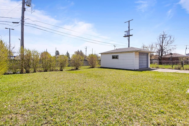 view of yard with an outdoor structure, fence, driveway, and a garage