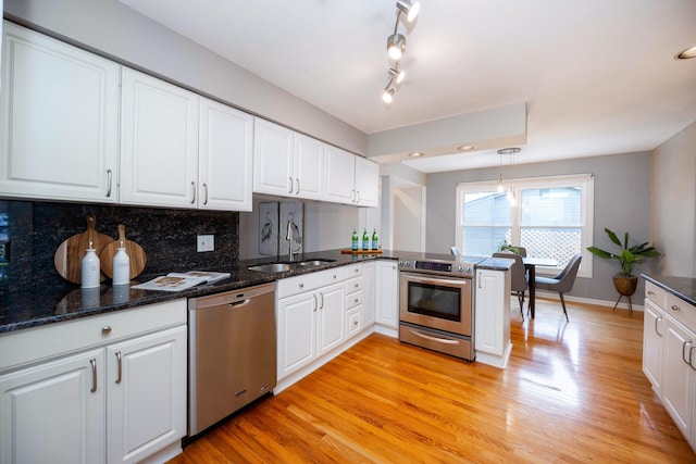 2015 Rugby Ct, Ann Arbor, MI 48103 - kitchen featuring appliances with stainless steel finishes, a sink, white cabinets, and light wood-style floors
