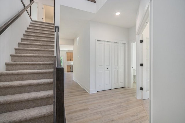stairs featuring baseboards, wood finished floors, and recessed lighting