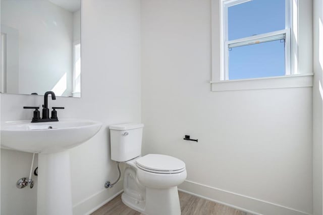 bathroom with plenty of natural light, baseboards, and wood finished floors