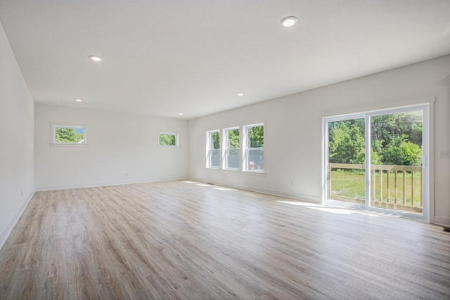 spare room with recessed lighting, wood finished floors, and baseboards
