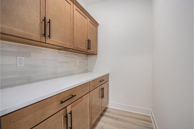 interior space with baseboards and light wood finished floors