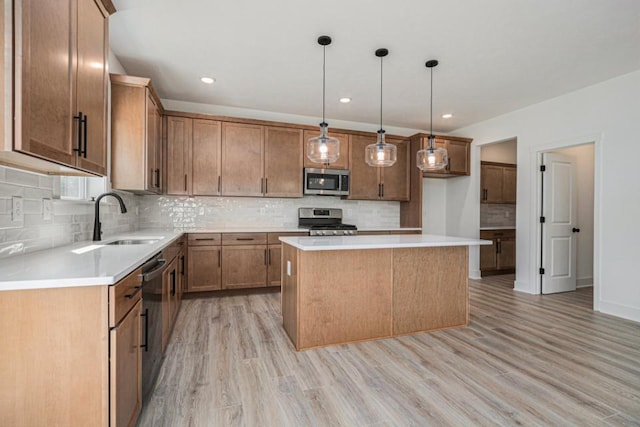 kitchen featuring decorative backsplash, stainless steel appliances, a sink, and light wood-type flooring