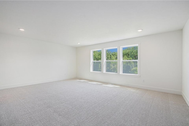 empty room with light colored carpet, baseboards, and recessed lighting