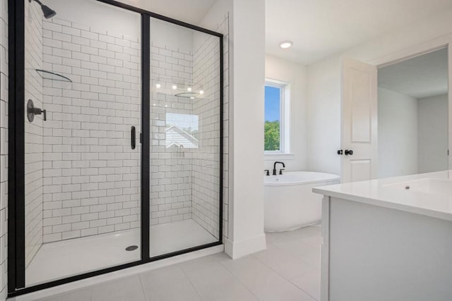 full bath with a shower stall, a freestanding tub, tile patterned flooring, and vanity