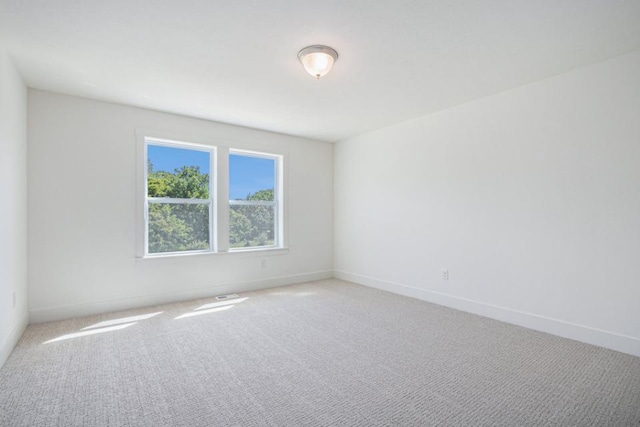 empty room with baseboards and light colored carpet