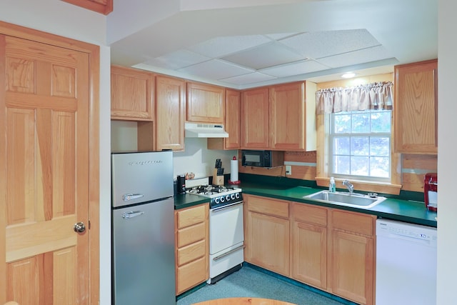 kitchen with under cabinet range hood, white appliances, a sink, and light brown cabinetry