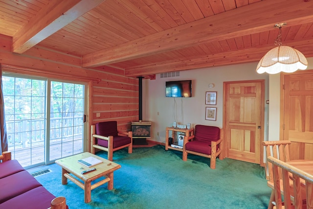 living area featuring beamed ceiling, a wood stove, wood ceiling, and visible vents