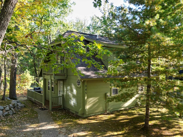 exterior space featuring a wooden deck and roof with shingles