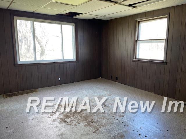 5225 N Vassar Rd, Akron, MI 48701 - empty room featuring wooden walls and a paneled ceiling