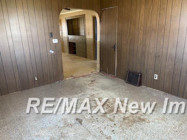 5225 N Vassar Rd, Akron, MI 48701 - carpeted empty room with wooden walls and arched walkways