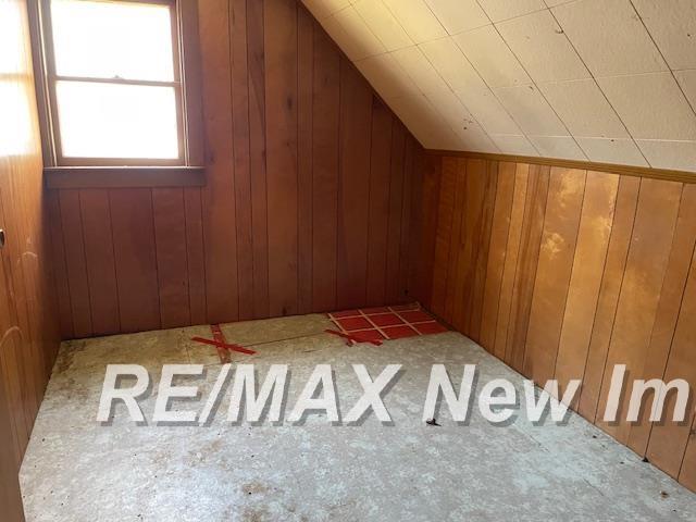 5225 N Vassar Rd, Akron, MI 48701 - bonus room with lofted ceiling, carpet flooring, and wood walls