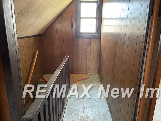 5225 N Vassar Rd, Akron, MI 48701 - staircase with wooden walls and vaulted ceiling