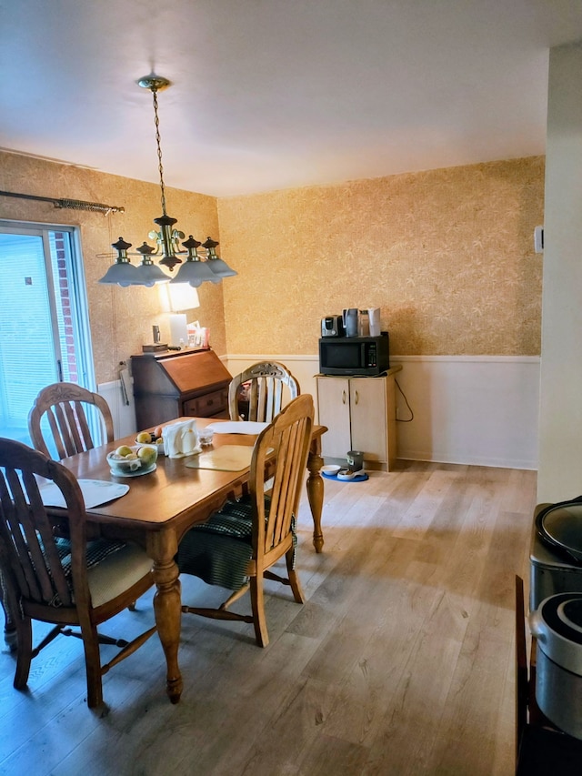 6689 Andersonville Rd Unit 29, Clarkston, MI 48346 - dining area with a wainscoted wall, light wood finished floors, and a chandelier